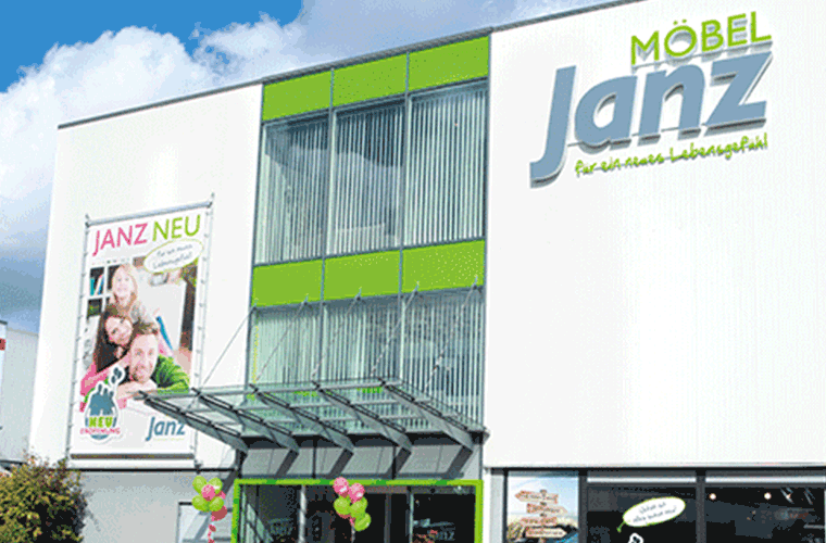 Aktuelles Möbel Janz Gebäudes mit grün-weißer Fassade.