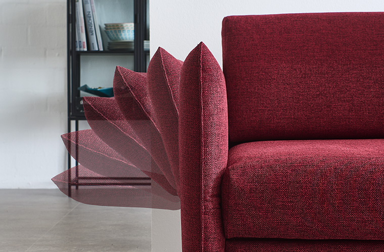 Detailaufnahme der Seitenlehne eines roten Schlafsofas.