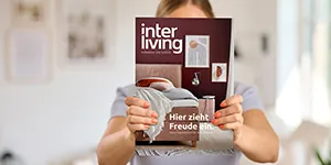 Frau hält Interliving Magazin in die Kamera.